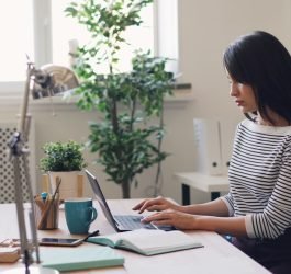 a woman sitting at a desk using a laptop computer