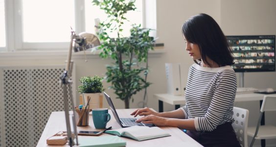 a woman sitting at a desk using a laptop computer