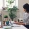 a woman sitting at a desk using a laptop computer