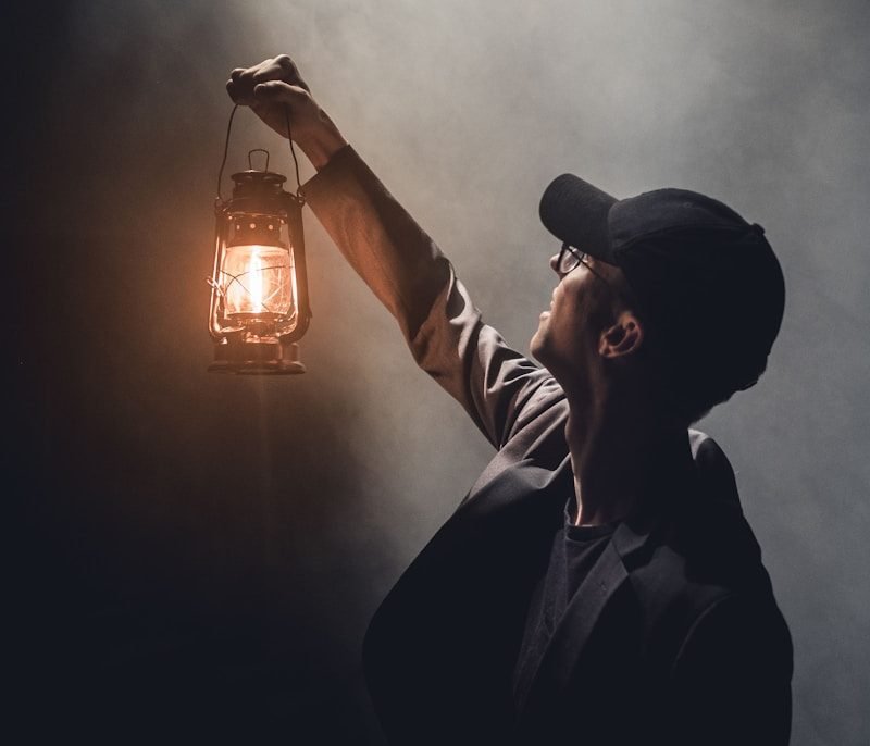 man holding lighted gas lantern