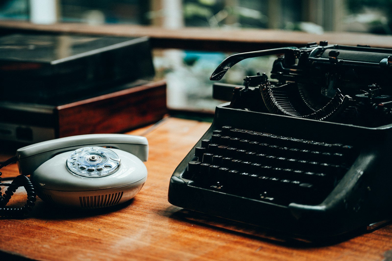 an old fashioned typewriter sitting on top of a wooden table