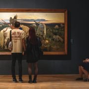 A group of people standing in front of a painting