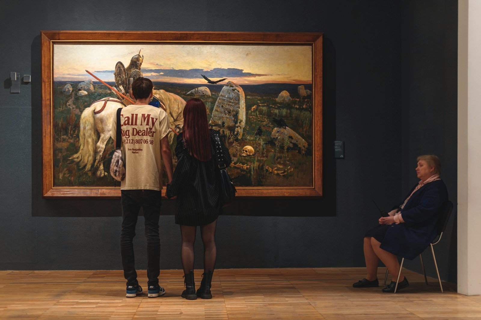 A group of people standing in front of a painting