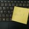 a yellow notepad on a keyboard