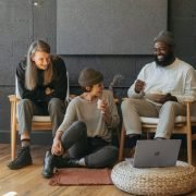 Three coworkers sitting together laughing Surface laptop on furniture