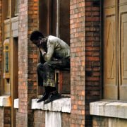 a man sitting on the ledge of a building