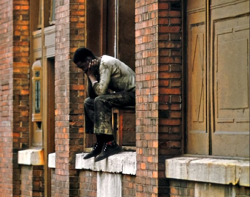 a man sitting on the ledge of a building